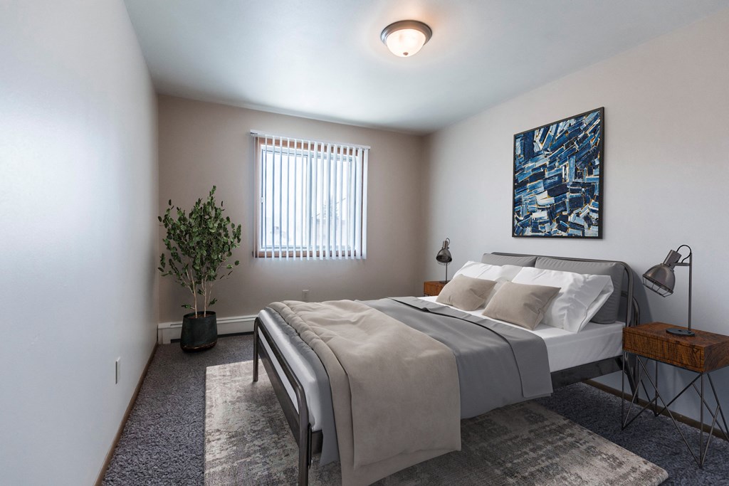 Grand Forks, ND Mayfair Apartments a bedroom with a large bed and a blue painting on the wall