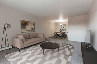 Grand Forks, ND Mayfair Apartments a living room with a couch and a table - Photo Gallery 2