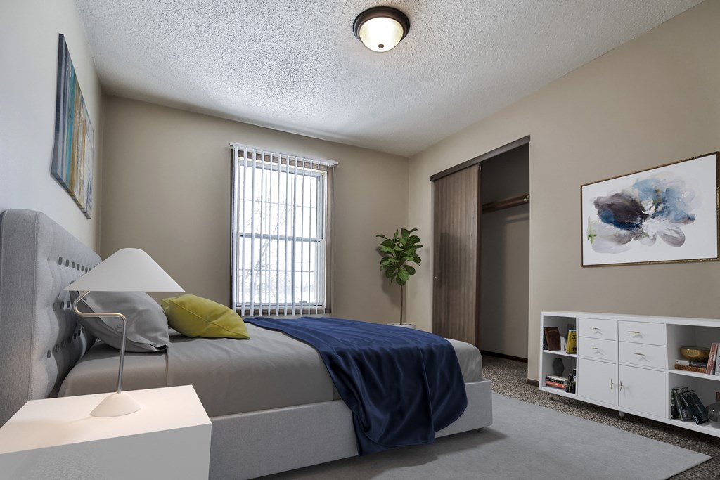 Grand Forks Primrose Apartments. A bedroom with a bed and a dresser in front of a window