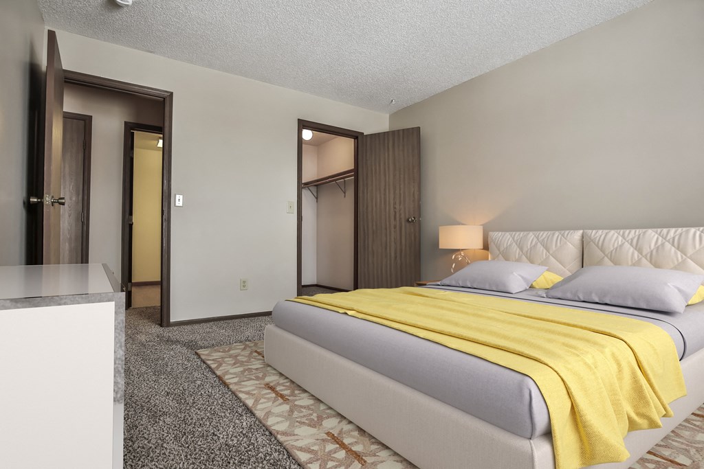 Grand Forks Primrose Apartments.a bedroom with a bed and a mirror