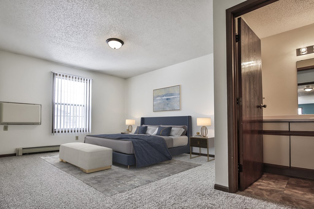 Grand Forks Kremer Apartments  a bedroom with a bed and a chair in a room