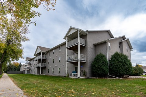 Grand Forks, ND Primrose Court Apartments. Exterior of a three level building with balconies and patios