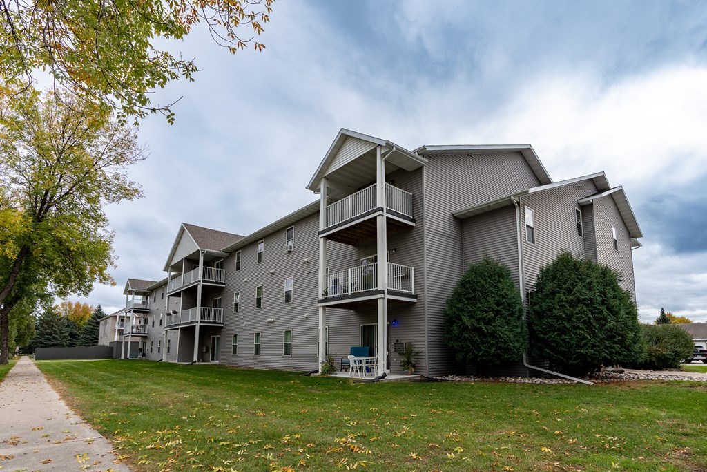 Grand Forks, ND Primrose Court Apartments | Exterior Grand Forks, ND Primrose Court Apartments. Exterior of a three level building with balconies and patios