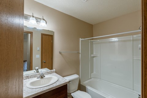 Grand Forks, ND Richfield Apartments. A bathroom with a sink, toilet, and bathtub