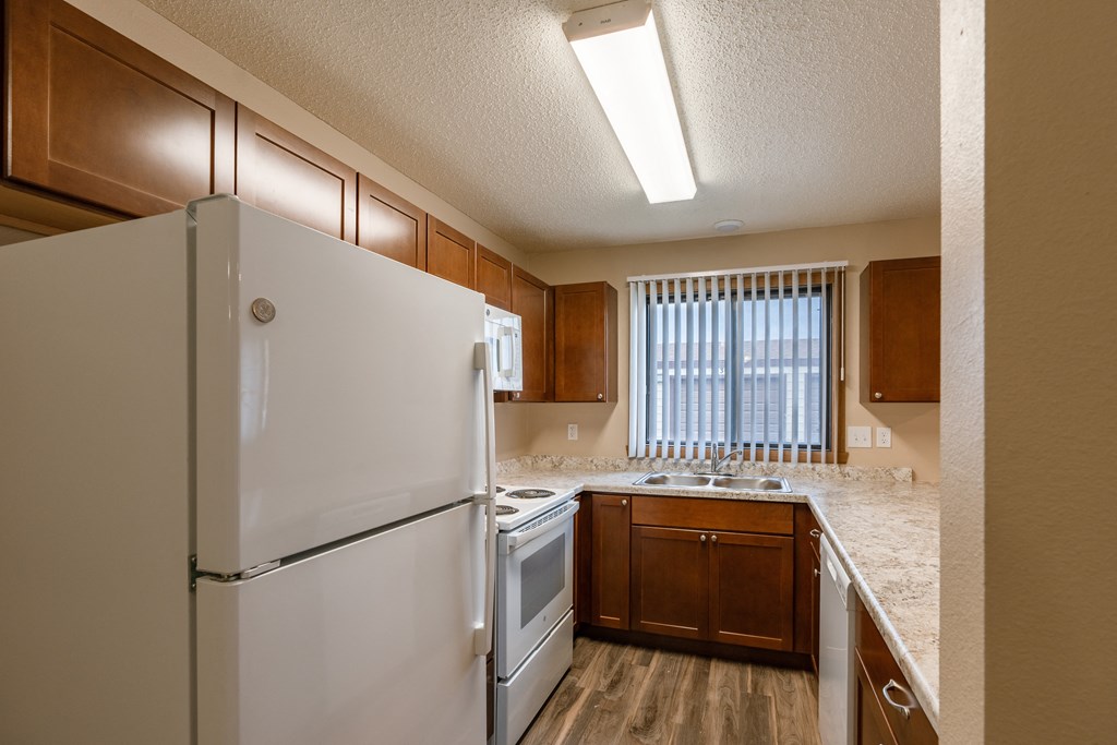 Grand Forks, ND Richfield Apartments. A kitchen with white appliances and a window.