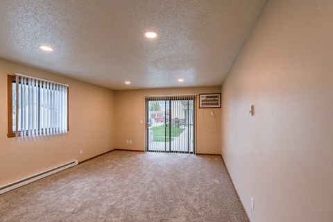 Grand Forks, ND Richfield Apartments. A living room with a sliding glass door to a patio