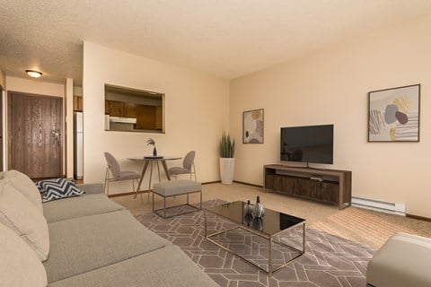 Grand Forks, ND Ridgemont Apartments. A living room with a couch table and chairs and a flat screen tv