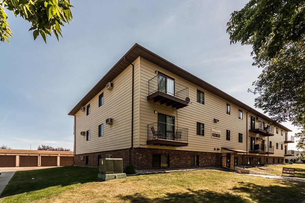 Grand Forks Ridgemont Apartments | Exterior Grand Forks Ridgemont Apartments. An exterior of a three level apartment building with garages in the background.