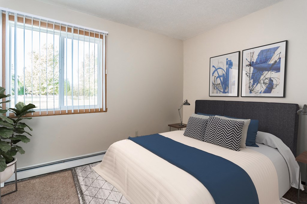 Grand Forks, ND Riverwood Apartments | Bedroom Grand Forks, ND Riverwood Apartments. A bedroom with a large bed and a window