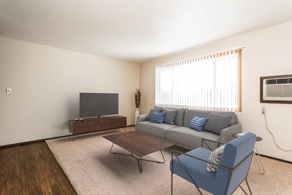 Grand Forks, ND Riverwood Apartments. A living room with a couch and a chair and a television