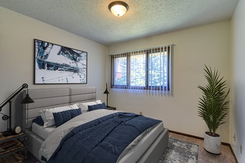 Grand Forks, ND Roughrider Apartments.  a bedroom with a large bed and two windows