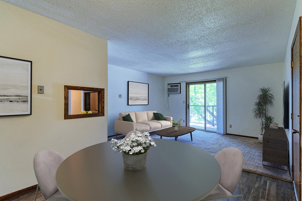 Grand Forks, ND Roughrider Apartments | Dining Grand Forks, ND Roughrider Apartments. a dining area with a table and chairs and a couch in the background
