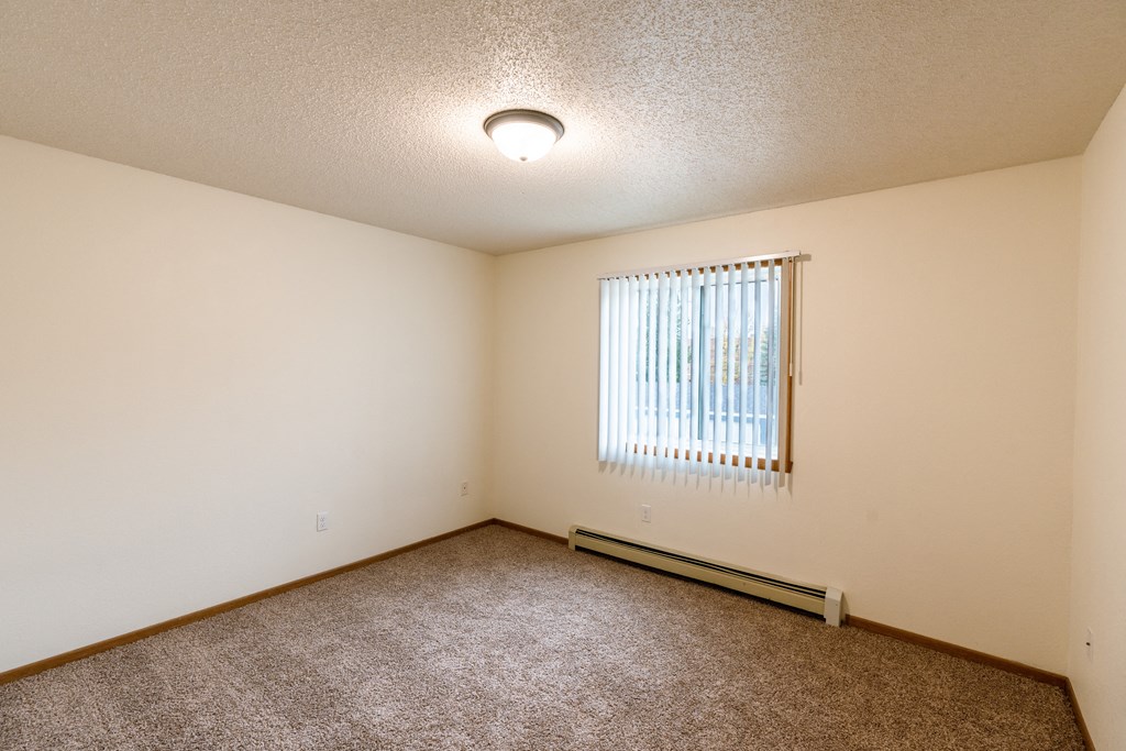 Grand Forks, ND Southview III Apartments. A living room with a window and carpeting