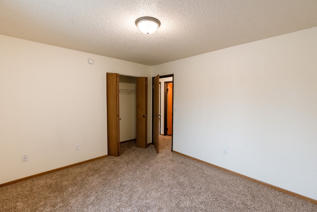 Grand Forks, ND Southview III Apartments. A room with carpet and a door to a hallway