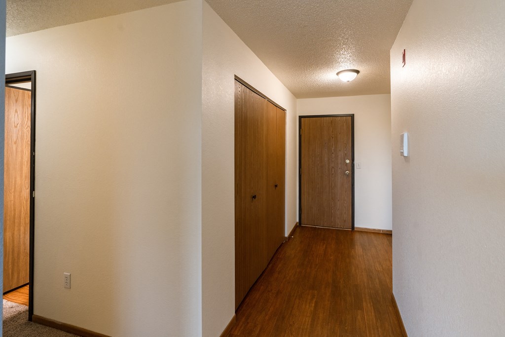 Grand Forks, ND Southview III Apartment. A hallway with a wooden door and a door to a closet