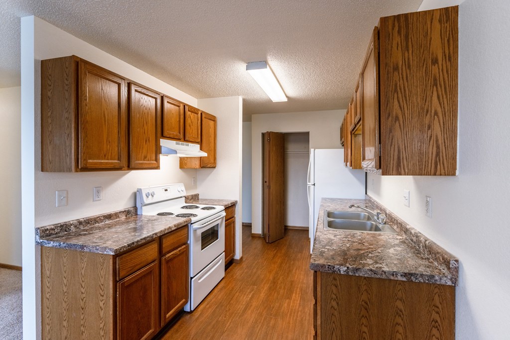 Grand Forks, ND Southview III Apartments. A kitchen with white appliances and granite counter tops