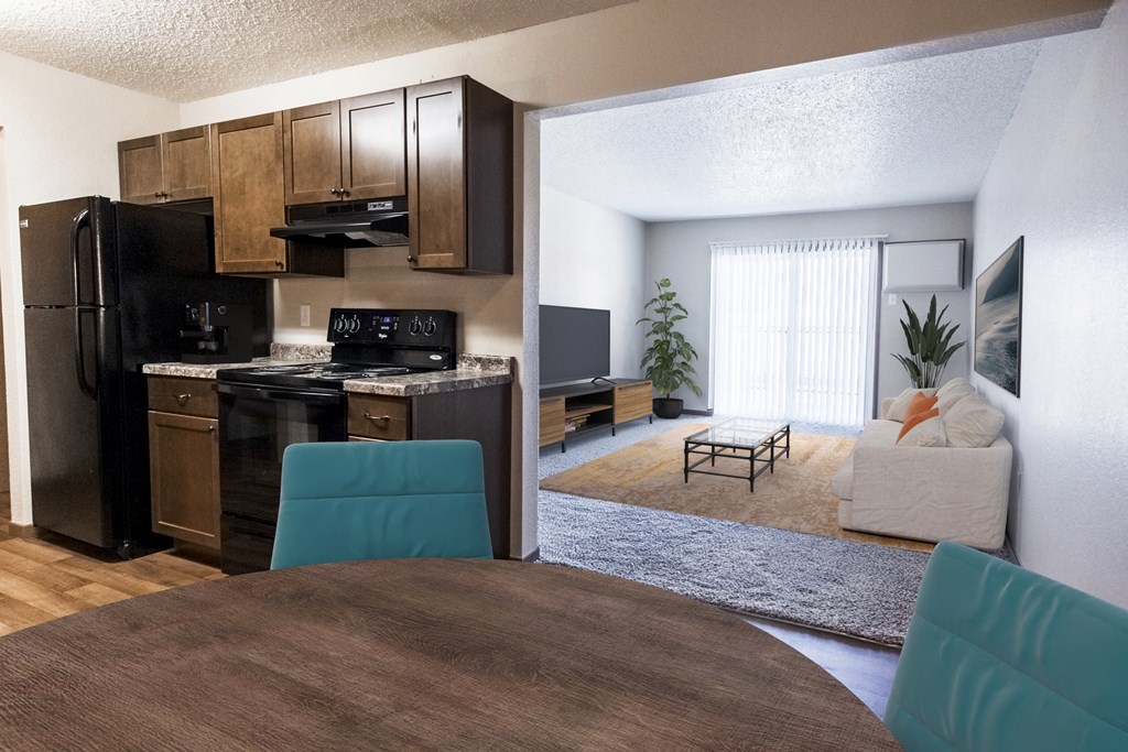 Grand Forks, ND Sunview apartments. A dining room with a table with four blue chairs and a living room in the background