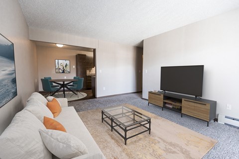 Grand Forks, ND Sunview apartments.  a living room with a couch and a coffee table with a tv and dining room in the background