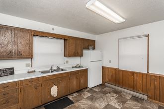 Grand Forks, ND Valley Home Duplex. a kitchen with white appliances and wooden cabinets