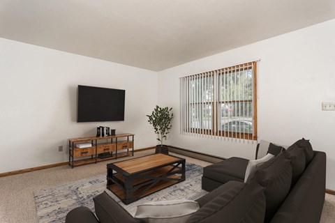 Grand Forks, ND Valley Home Duplex.  a living room with a couch and coffee table and a tv on the wall