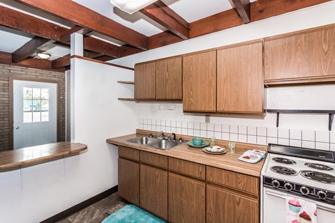 a kitchen with wooden cabinets and a stove and a sink