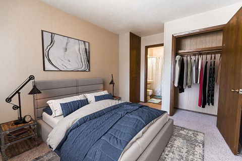 a bedroom with a bed and a closet with clothes in it