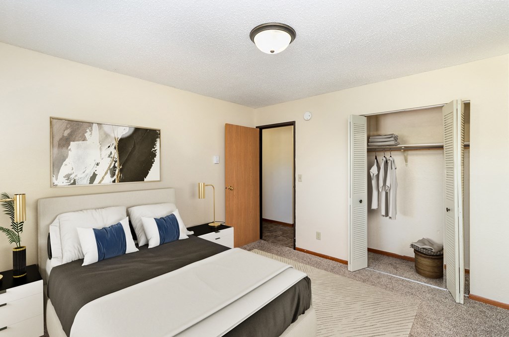 a bedroom with a large bed and a closet. Hutchinson, MN Echo Manor Apartments