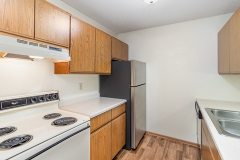 a kitchen with white appliances and wooden cabinets and a refrigerator
