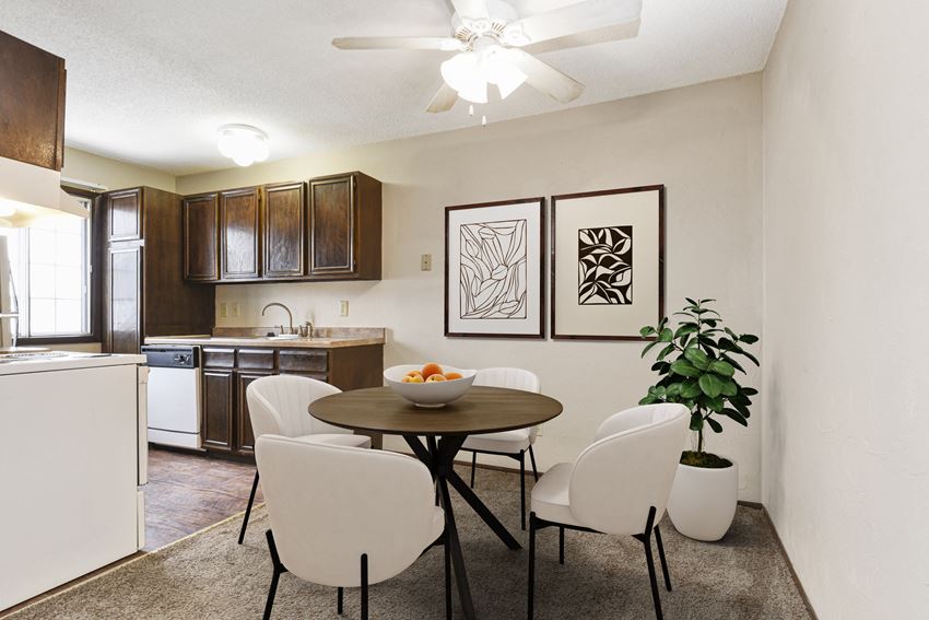 Georgetown on the River Apartments, Fridley, MN. A furnished dining room Georgetown on the River Apartments, Fridley, MN. a dining area with a table and chairs and a kitchen in the background - Photo Gallery