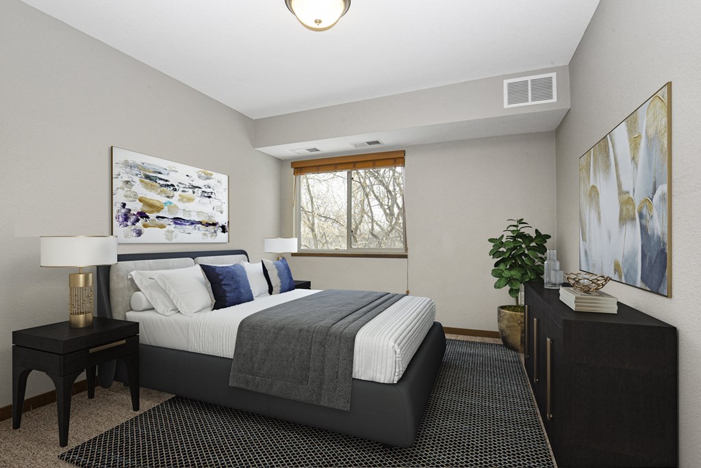 Georgetown on the River Apartments, Fridley, Minnesota. A bedroom with a bed and two night stands.