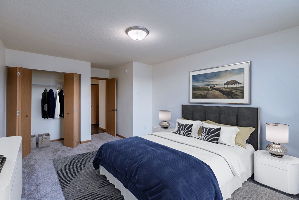 a bedroom with a bed and a closet. Moorhead, MN South Park Apartments