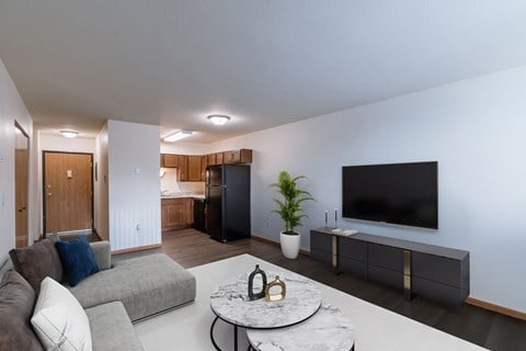 a living room with a tv and a kitchen. Moorhead, MN South Park Apartments