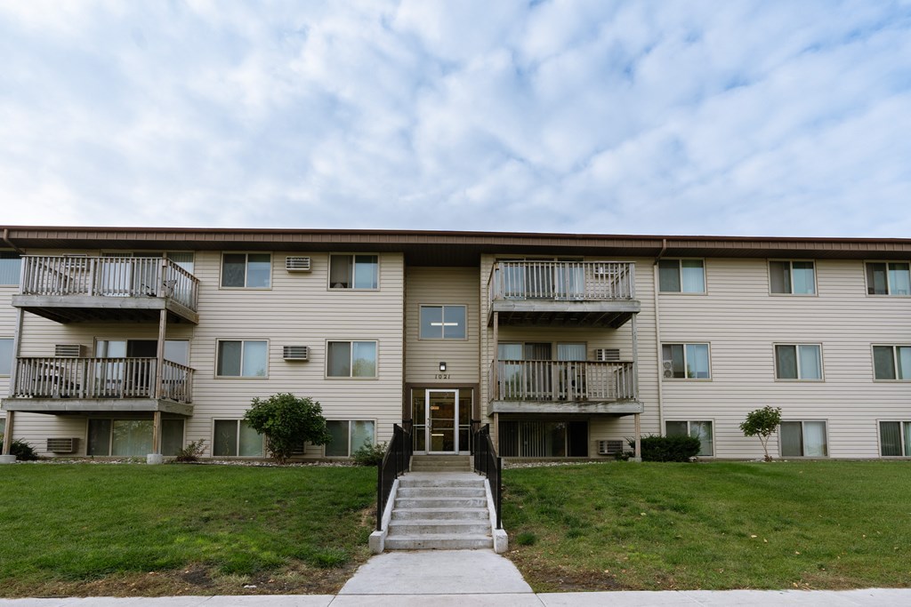an apartment building with stairs and a green lawn. Moorhead, MN South Park Apartments