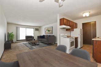 a dining area in Sage Park, a residential complex in New Brighton. The room features modern furniture, including a sleek dining table surrounded by comfortable chairs. Soft lighting creates a cozy ambiance, with large windows