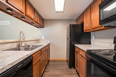 a kitchen with wooden cabinets and a sink and a refrigerator