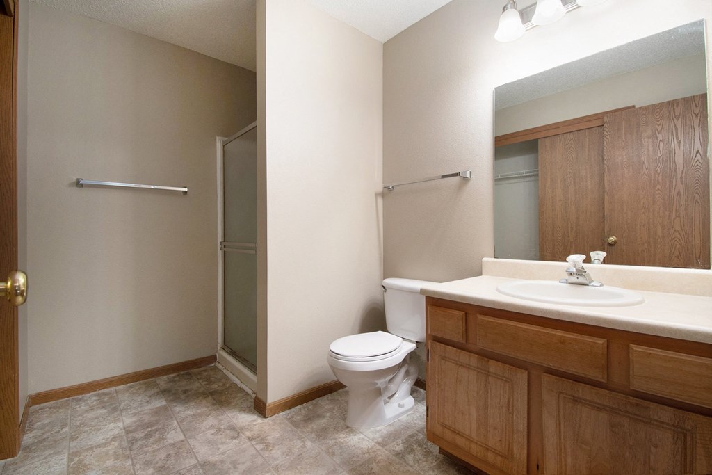 Omaha, NE Deerfield Apartments. A bathroom with a toilet sink and shower