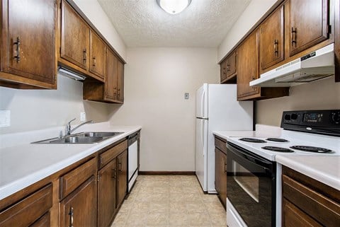 Omaha, NE Maple Ridge Apartment. A kitchen with white countertops and wooden cabinets