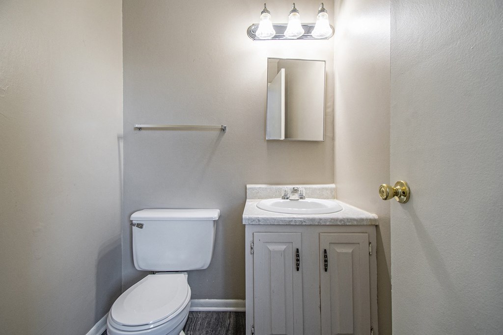 Omaha, NE Maple Ridge Apartments. A bathroom with a toilet sink and mirror