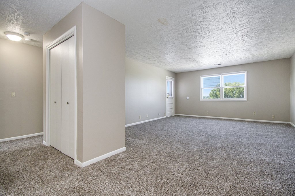 Omaha, NE Maple Ridge Apartment. A bedroom with carpet and a door to a bathroom