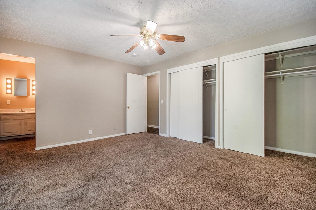 Omaha, NE Maple Ridge Apartments. A bedroom with carpeted floors and a ceiling fan