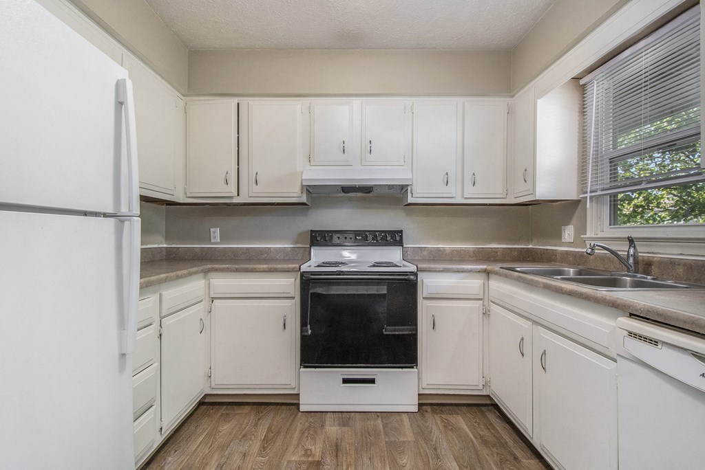 Omaha, NE Maple Ridge Apartments. A kitchen with white cabinets and white appliances