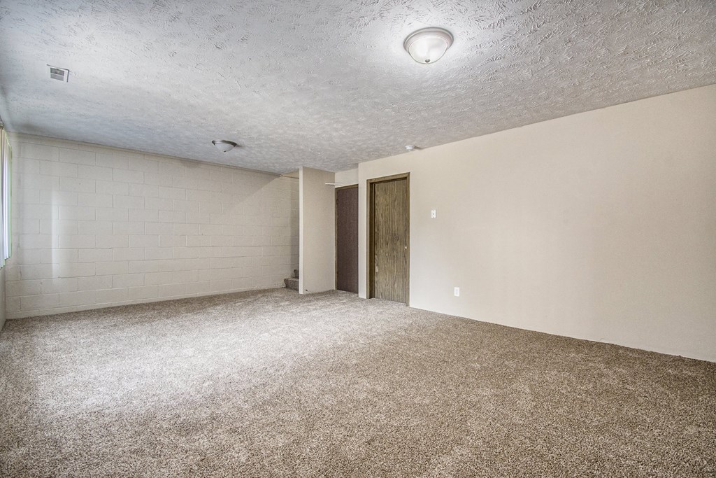 Omaha, NE Stony Brook Townhomes.  A spacious living room with carpeted flooring and white walls