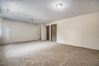 Omaha, NE Stony Brook Townhomes.  A spacious living room with carpeted flooring and white walls