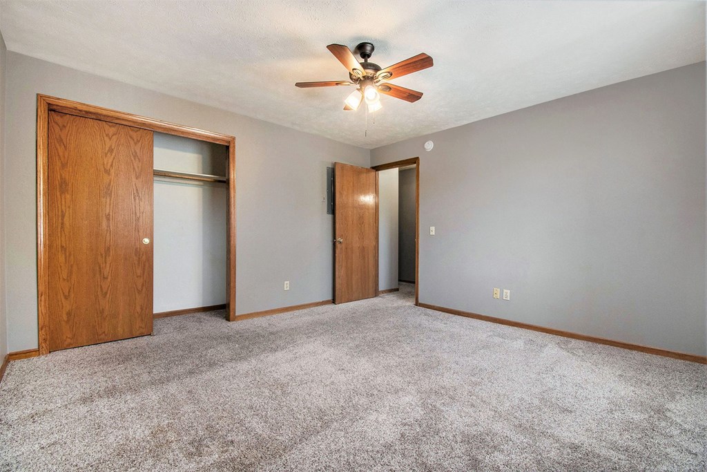 Omaha, NE Woodland Pines Apartments. A bedroom with a ceiling fan and two doors