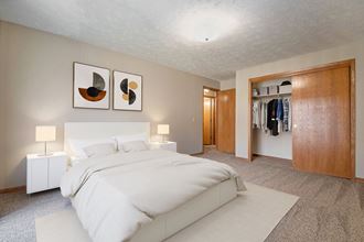 Omaha, NE Woodland Pines Apartments. A bedroom with a bed and a wardrobe - Photo Gallery 2