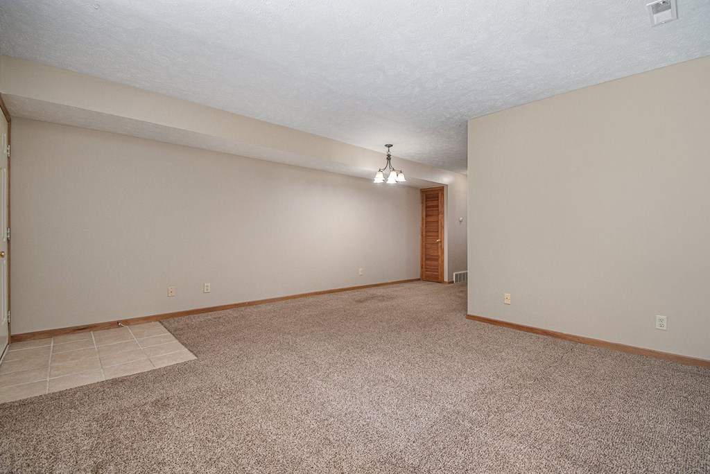 a living room and dining room with carpeted floors. Omaha, NE Woodland Pines Apartments