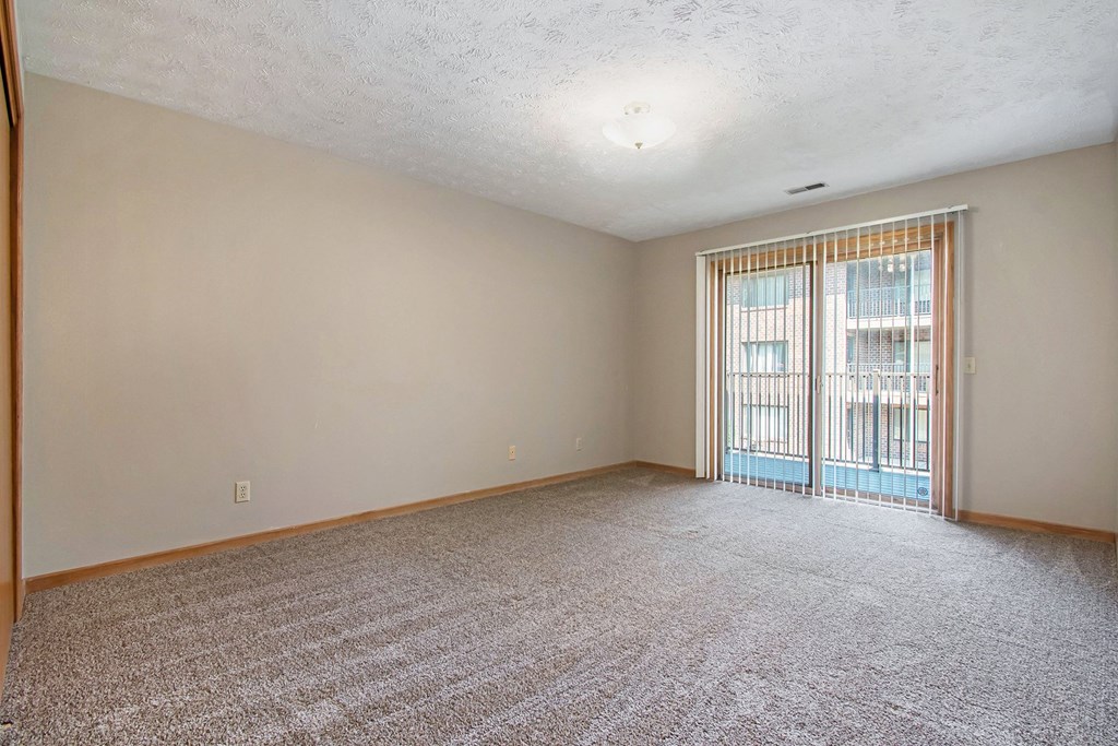 Omaha, NE Woodland Pines Apartments. A living room with a sliding glass door