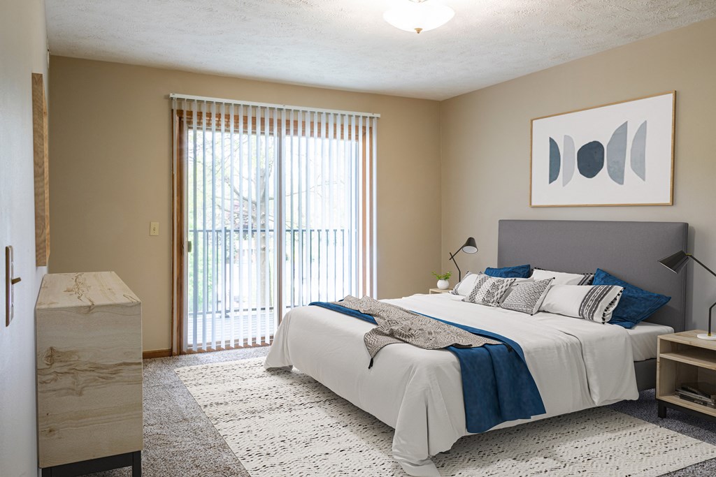 a bedroom with a bed and a sliding glass door  at Woodland Pines, Omaha, Nebraska