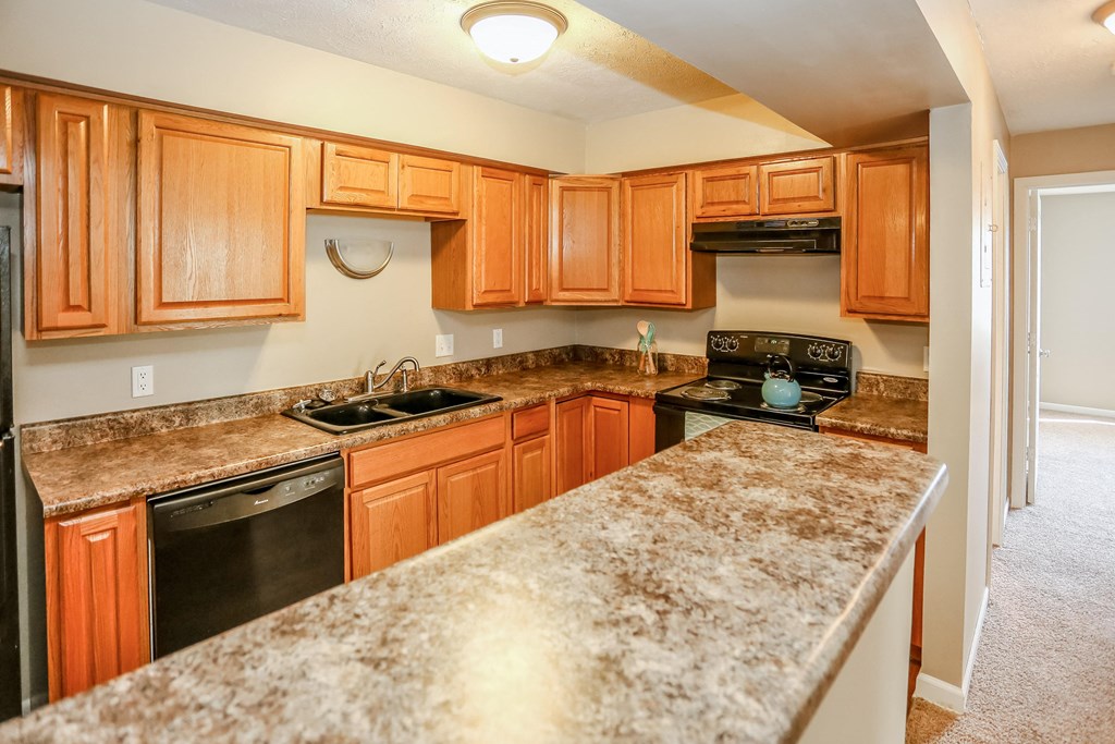 a kitchen with granite counter tops and wooden cabinets. Omaha, NE Evergreen Terrace Apartments