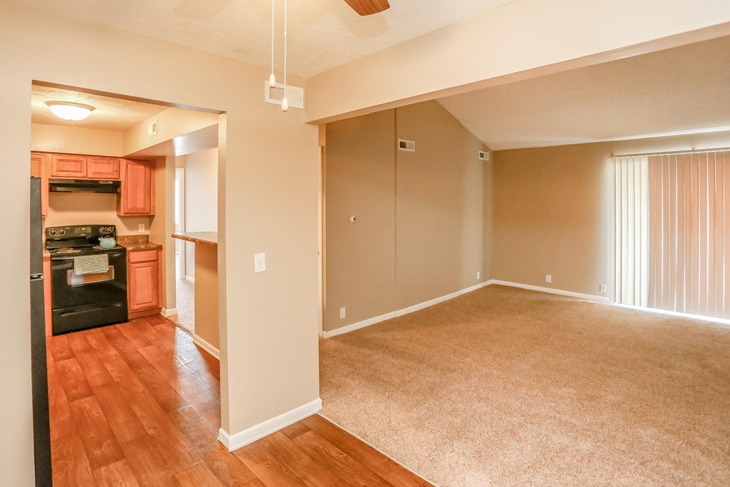 an empty living room and kitchen with wood flooring. Omaha, NE Evergreen Terrace Apartments